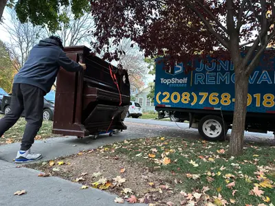 Top Shelf crew removing a piano from a Boise home with branded junk removal truck